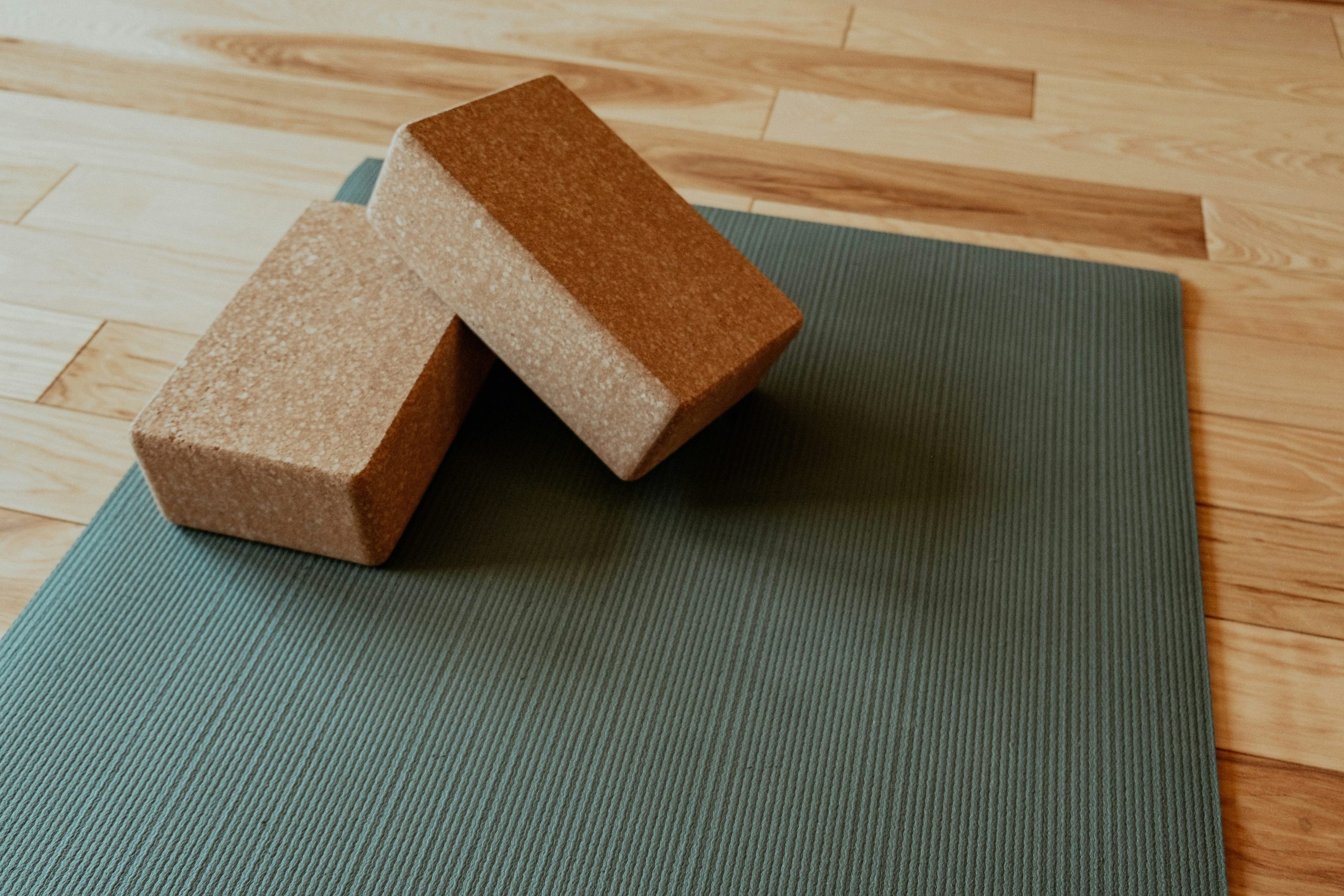 Grüne Yoga-Matte mit passenden Yoga-Blöcken als Ausrüstung für Entspannung und Achtsamkeit im Grounded-Projekt